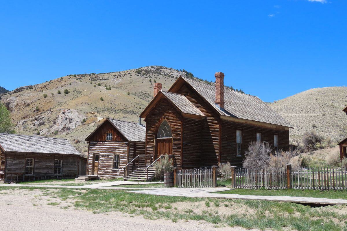 A group of wooden buildings in Bannack State Park is nestled in the middle of a mountain in Montana.