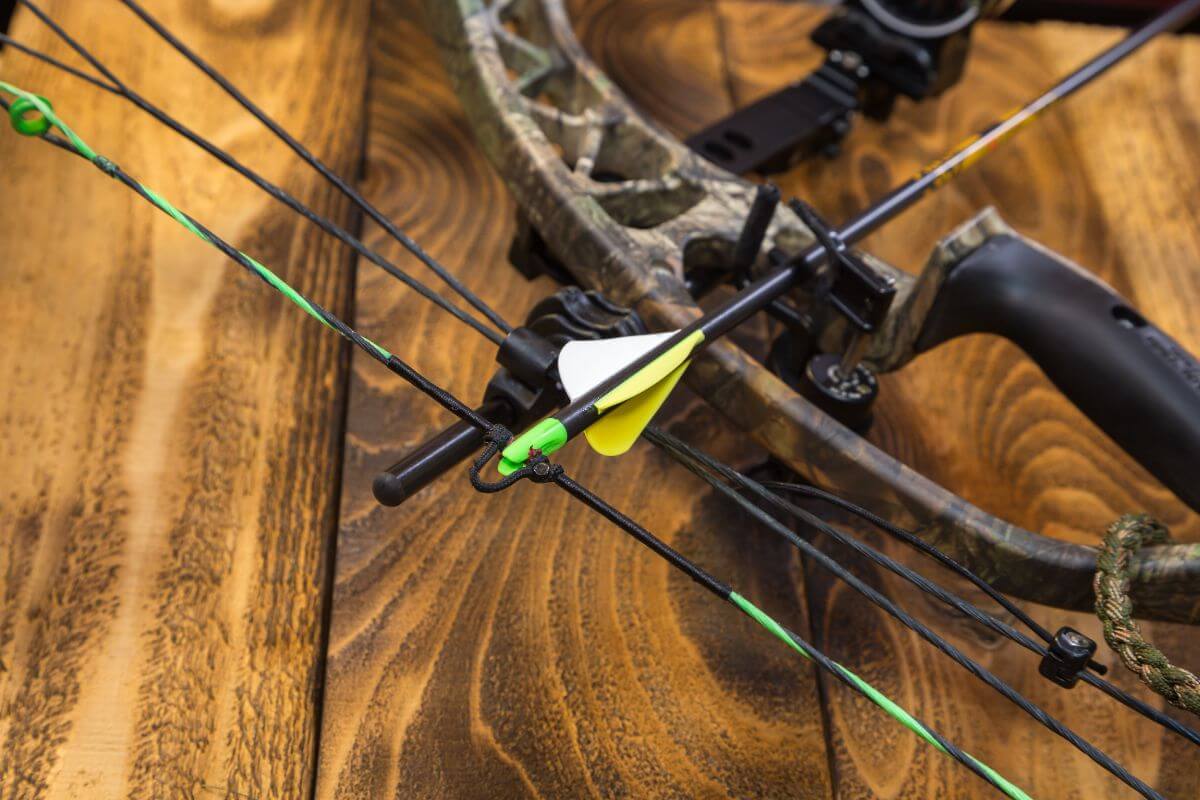 A close-up of a compound bow with an arrow on a wooden table in Montana