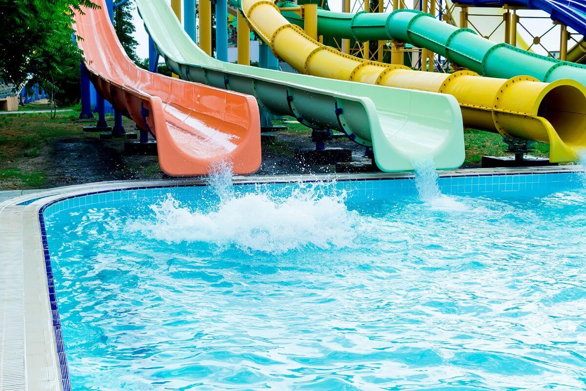 Water slides of different colors and shapes, including tubular slides, lead to a clear pool at Montana's Ridge Water's Waterpark.