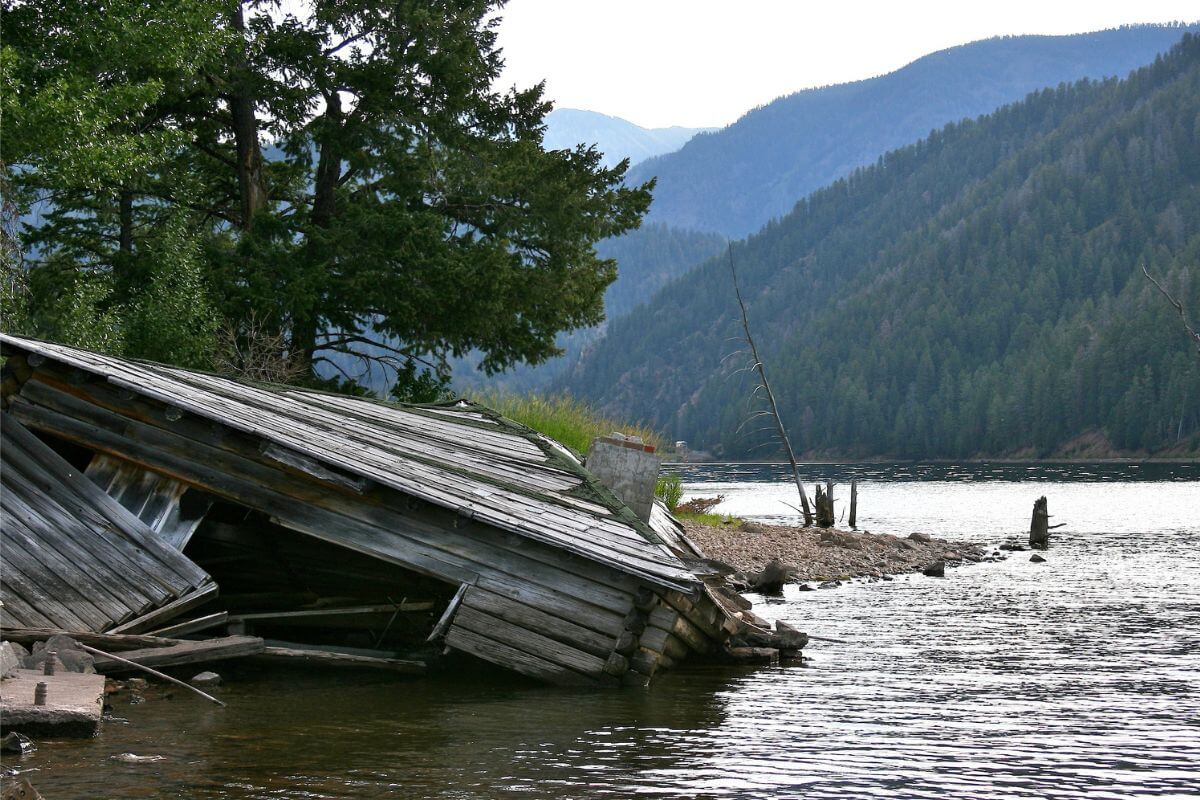 An old wooden house submerged on the shore of a lake in Montana due to an earthquake.