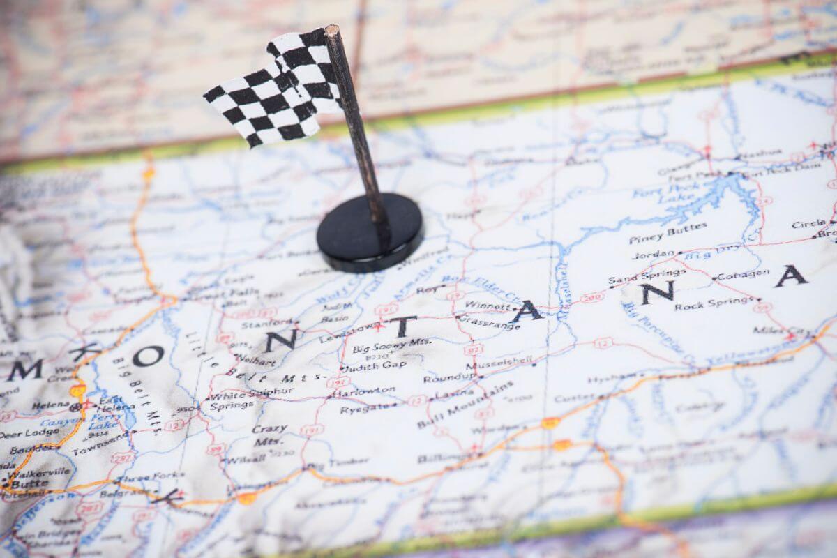 A checkered flag pinned to a map of Montana.