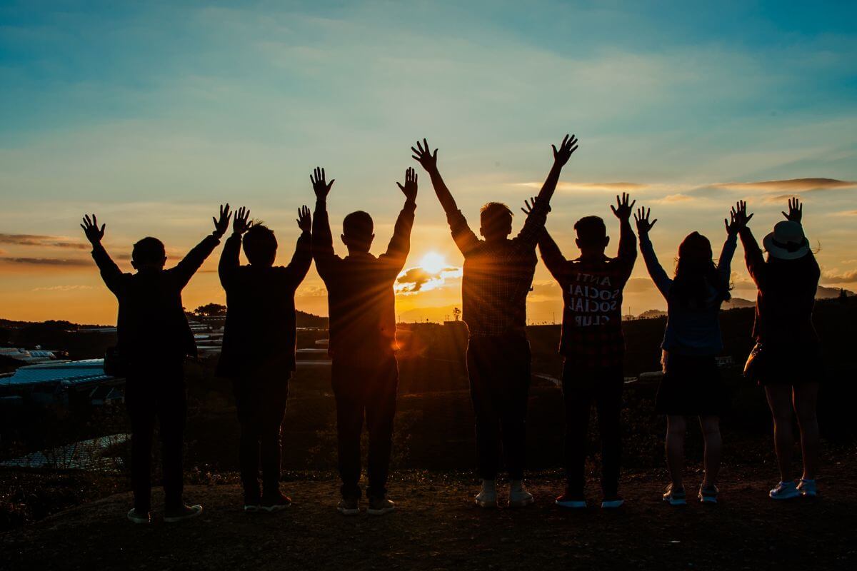 Seven People in Montana with Two Arms Up Looking at the Sunset