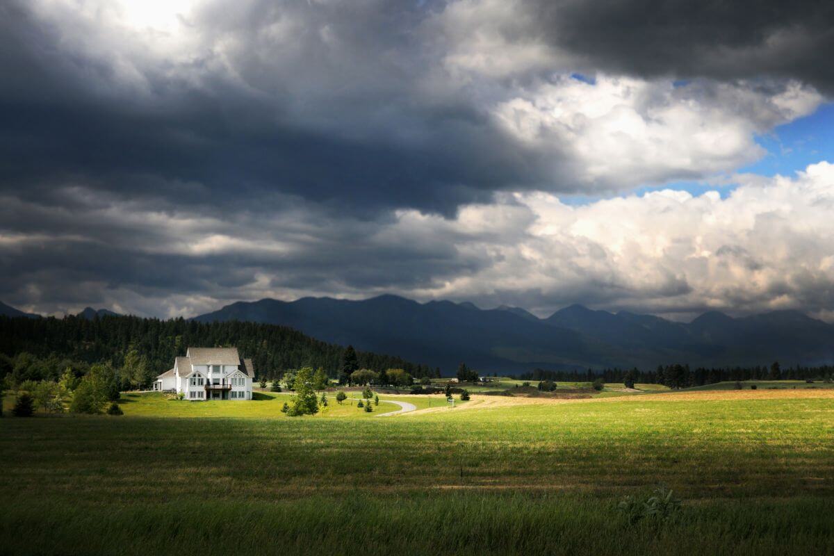 A house under a cloudy sky in the mountains of Montana.