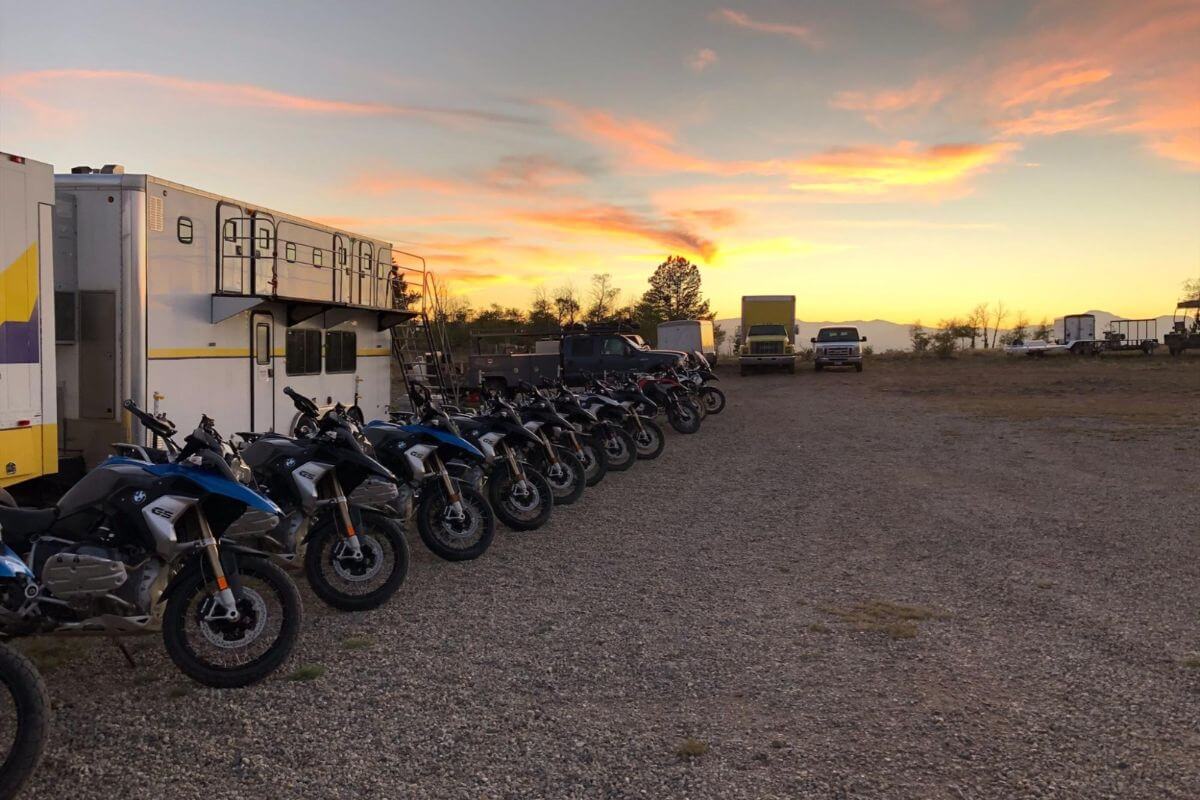A fleet of dirt bikes lined up in a dirt lot at RawHyde Adventures