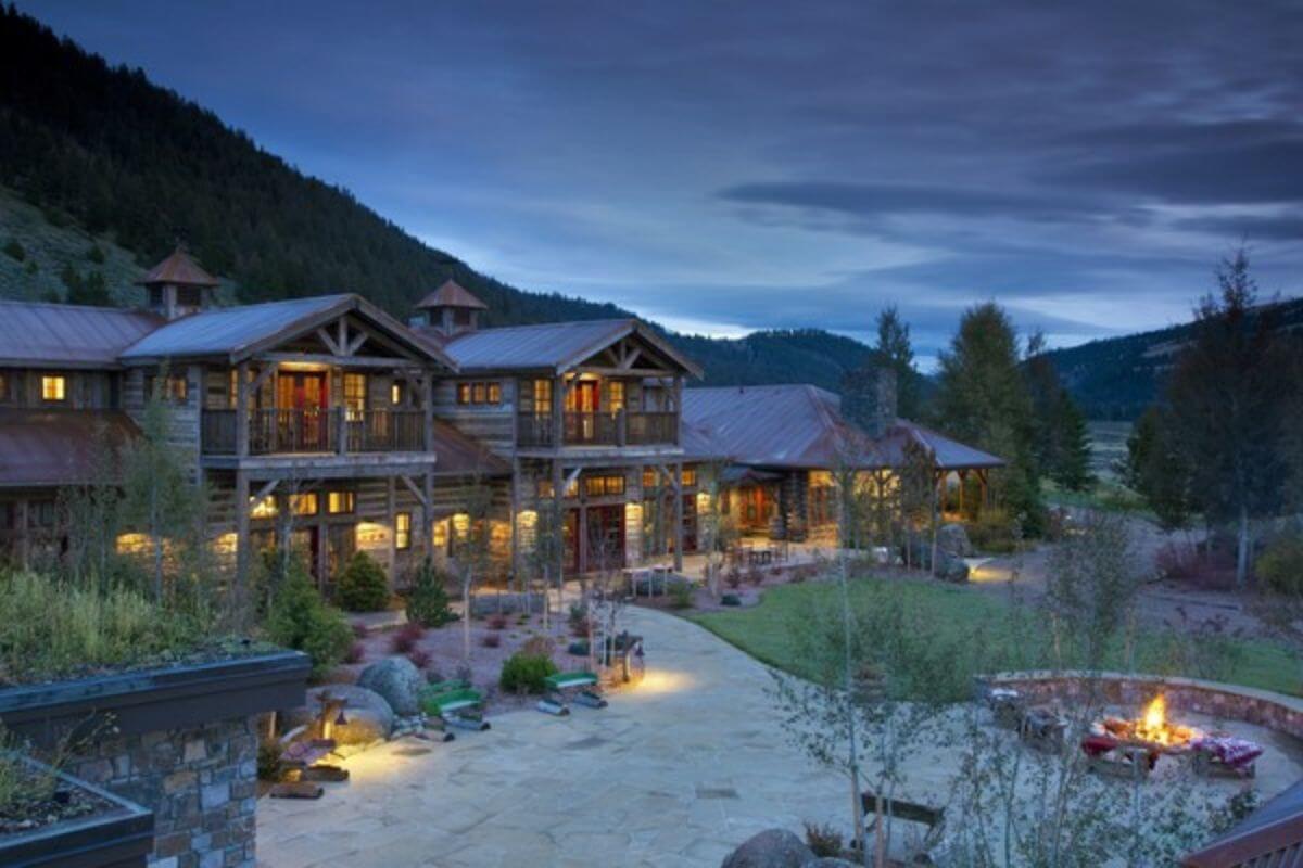 Log cabins that are lit from the inside in the mountains of Montana.