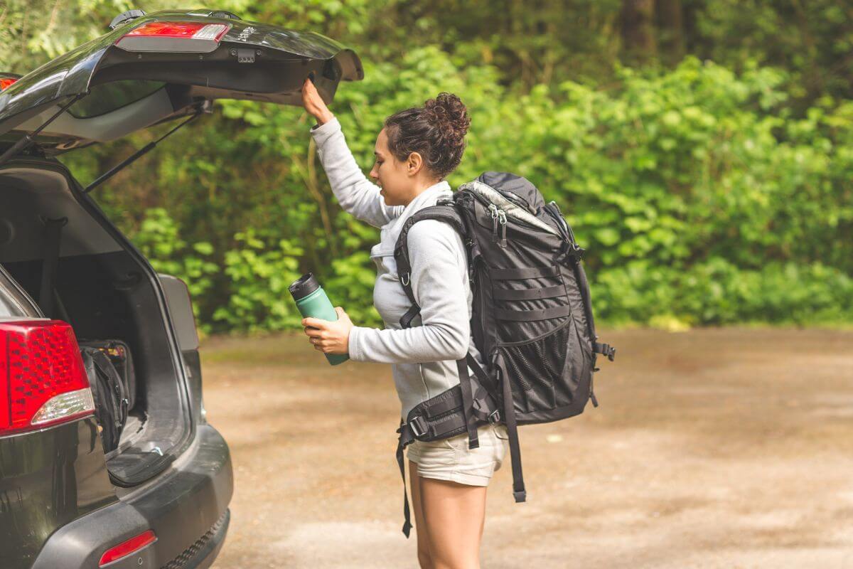 A hiker checks her car trunk, ensuring everything's set for the trip to Lost Creek Waterfall in Montana.
