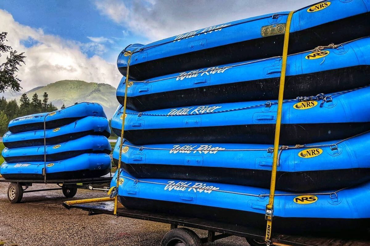 Rafting Trips With Wild River Adventure's blue inflatable rafts stacked on top of each other on trailers