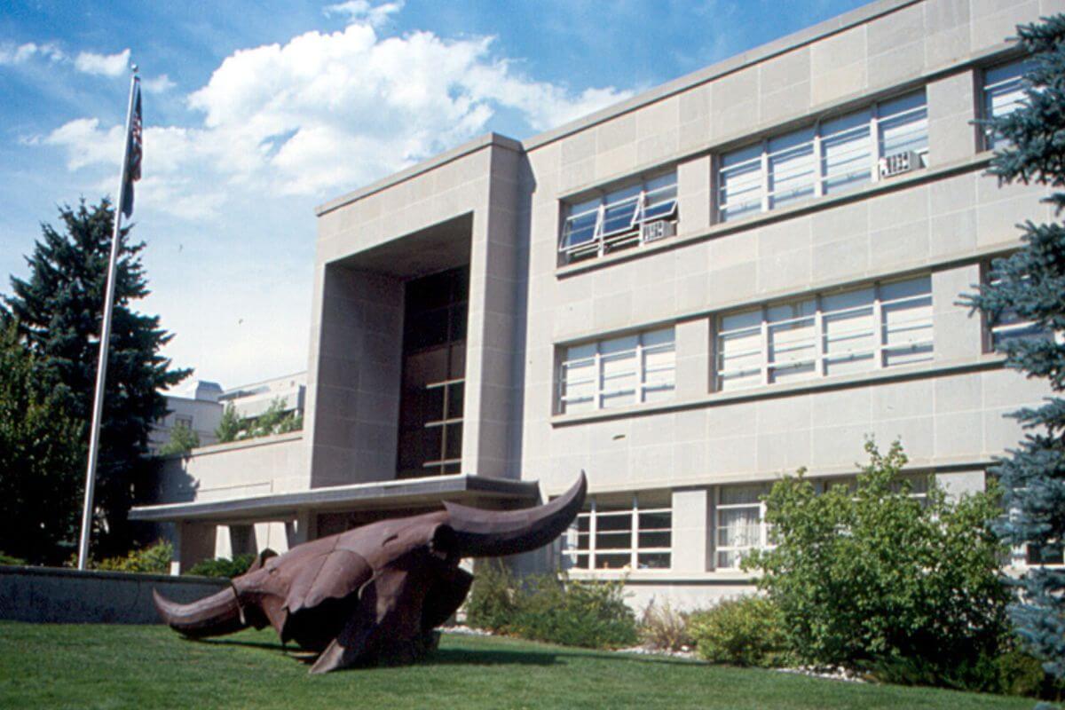 A Large Building in Montana With a Statue of a Bull Head in Front