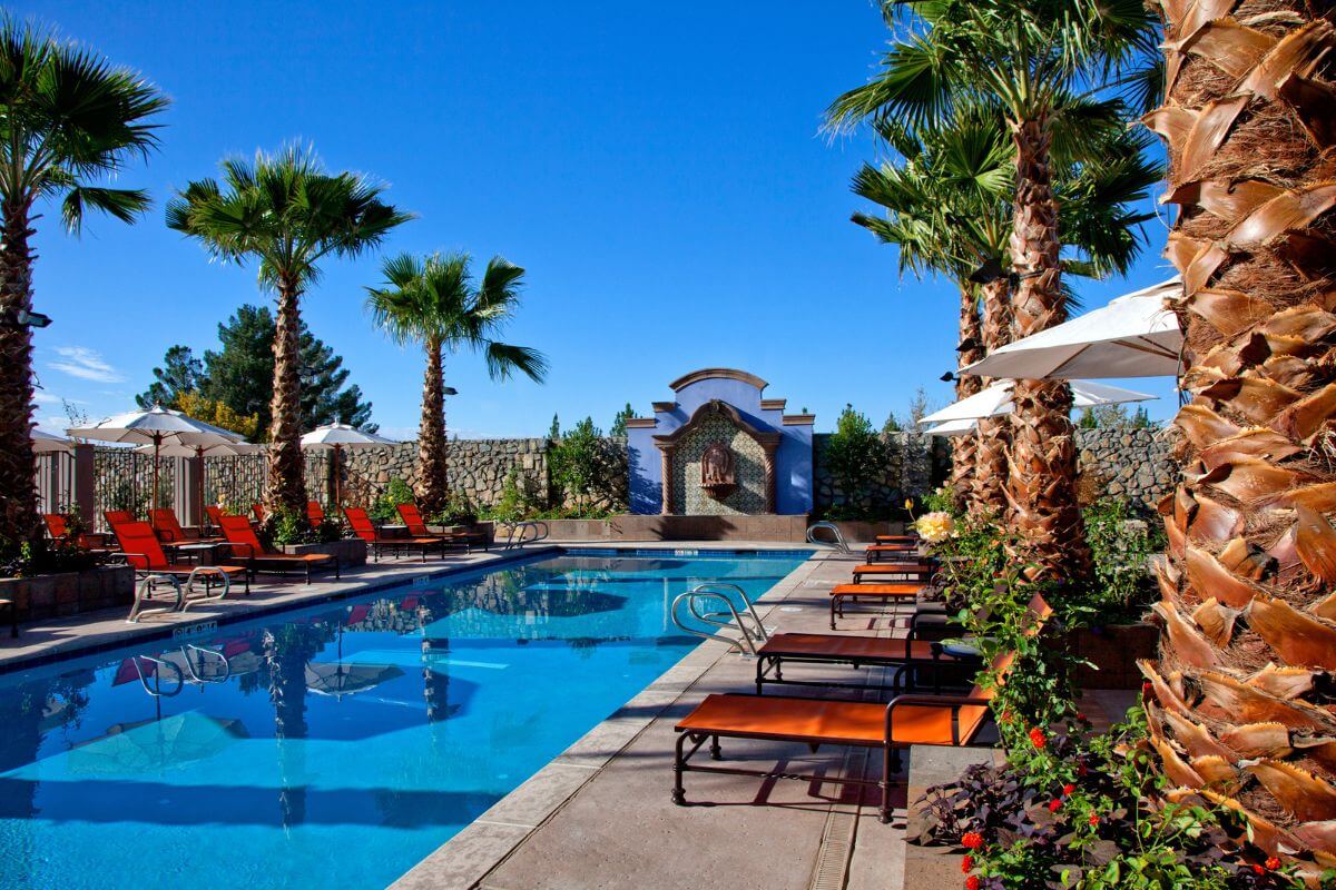 A swimming pool with lounge chairs and palm trees located in Montana.