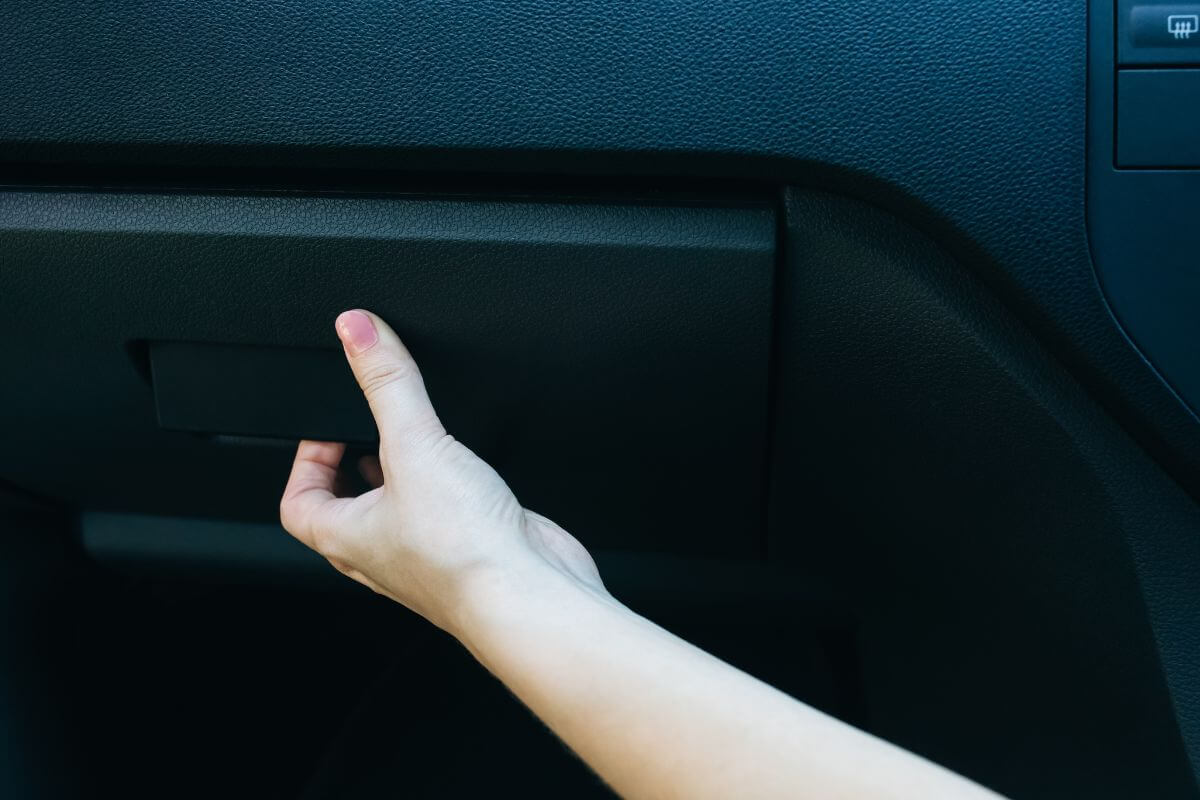 Hand of a Woman Opening a Glove Compartment