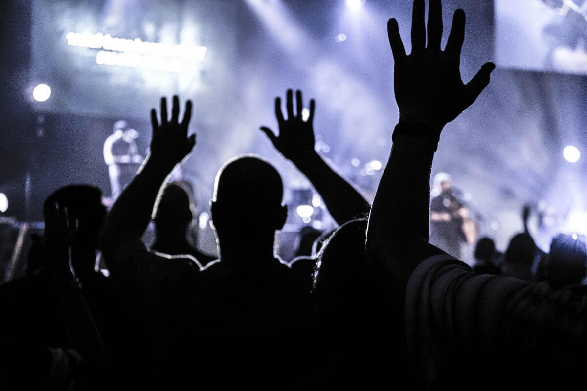 A crowd at a concert in Montana raising their hands.