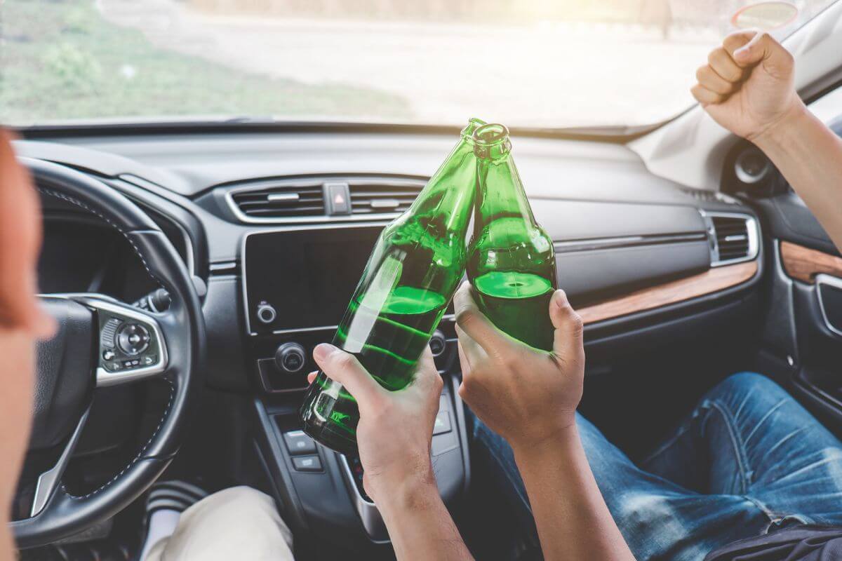 Two People With Green Bottles of Alcohol While Driving