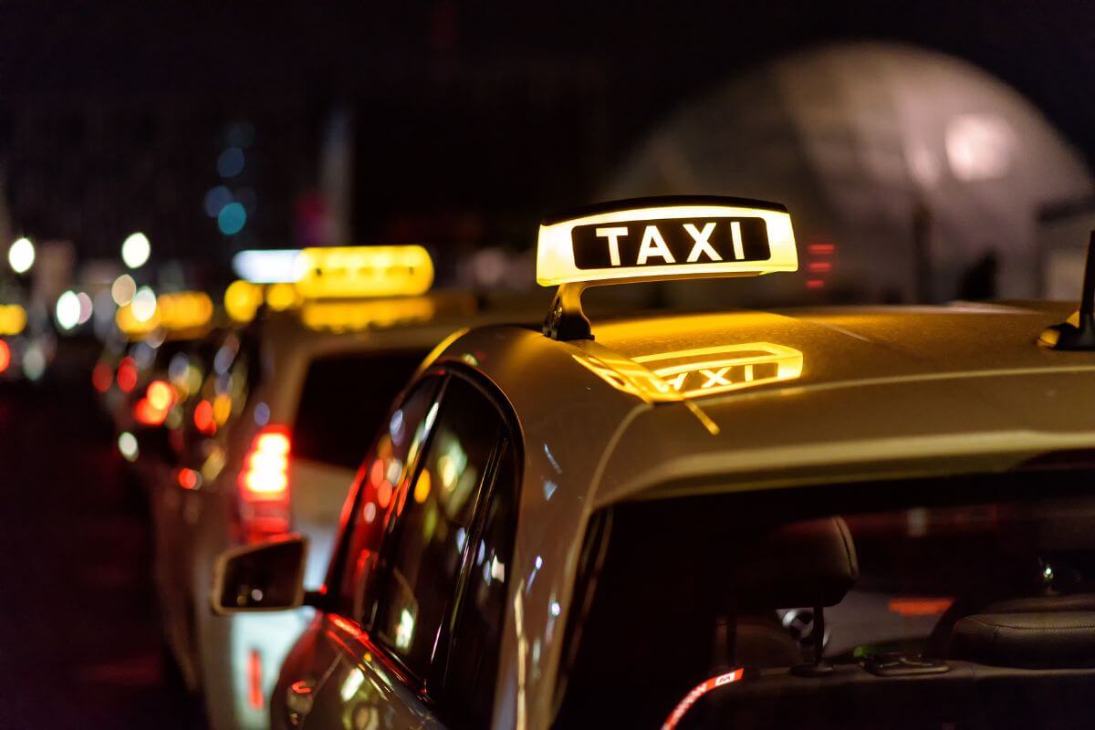 A group of taxis lining a Montana street at night.