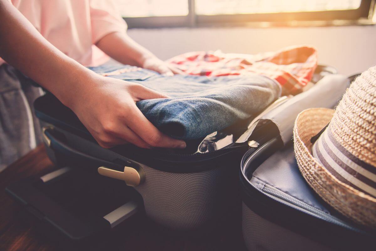 A woman is packing clothes into a suitcase for a Montana summer trip.