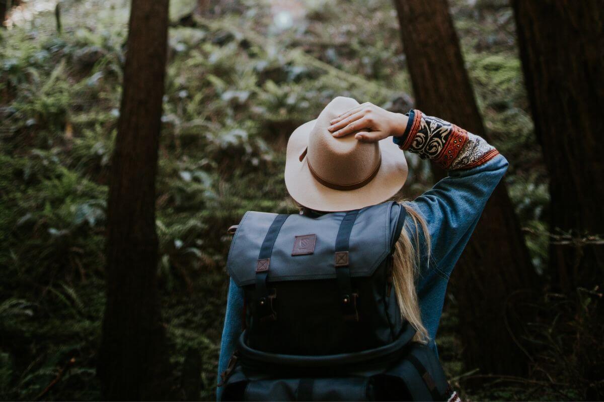 A woman wearing a hat and backpack in Montana. 
