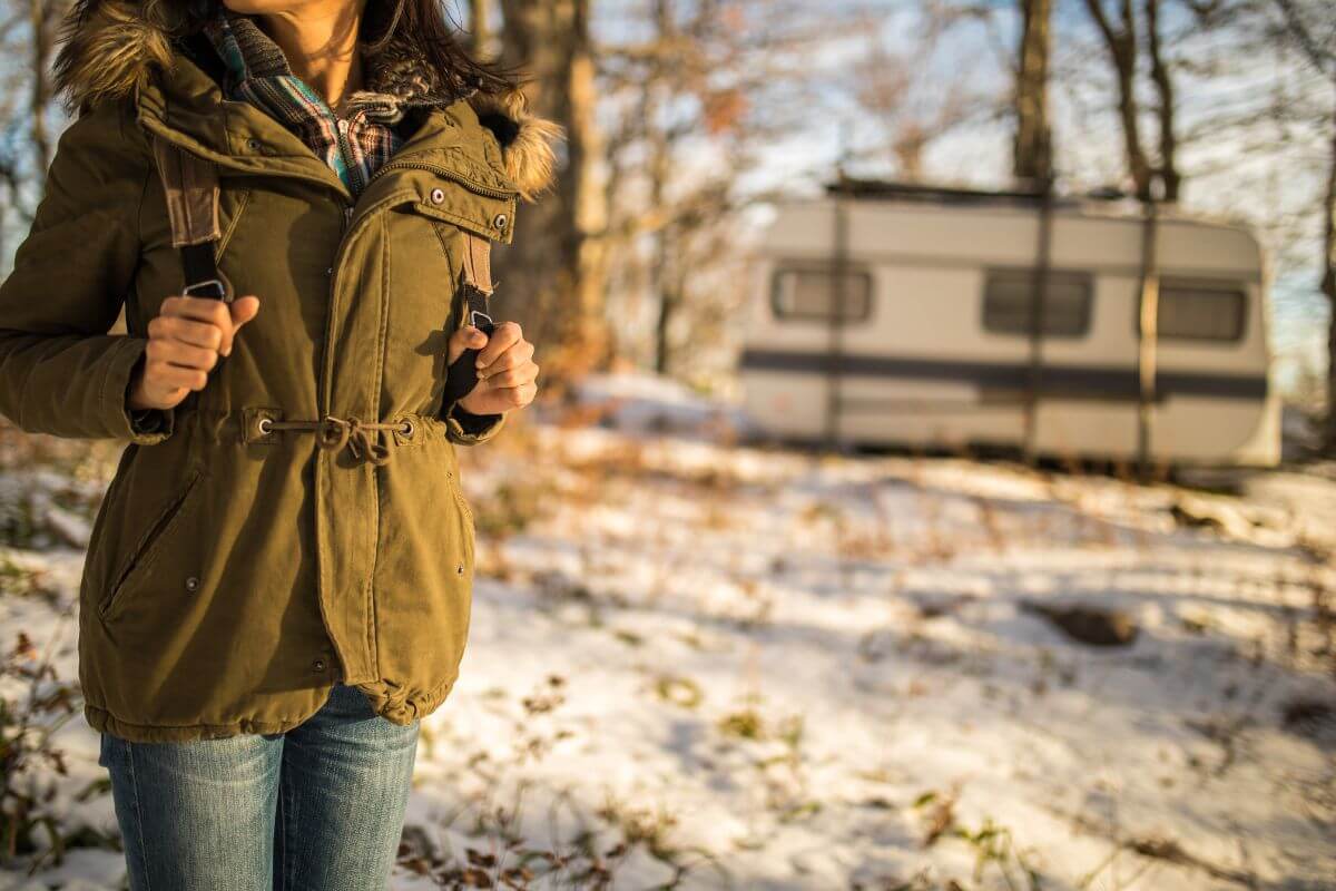 A woman in a jacket standing in front of an RV in Montana.