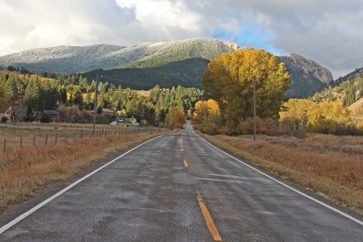 An empty road in Montana with mountains in the background.