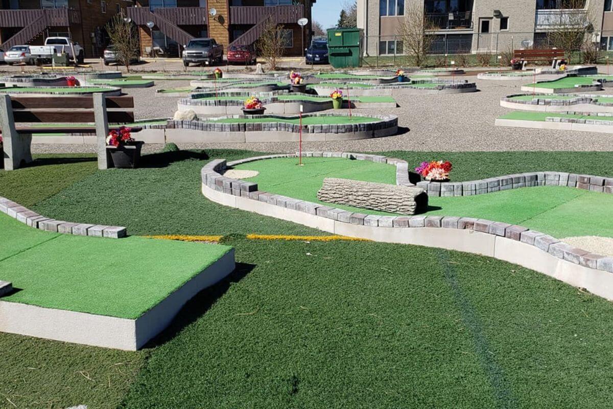 The Flippin' Family Fun mini golf course in Great Falls, Montana with artificial grass, rocks, and stone paths.
