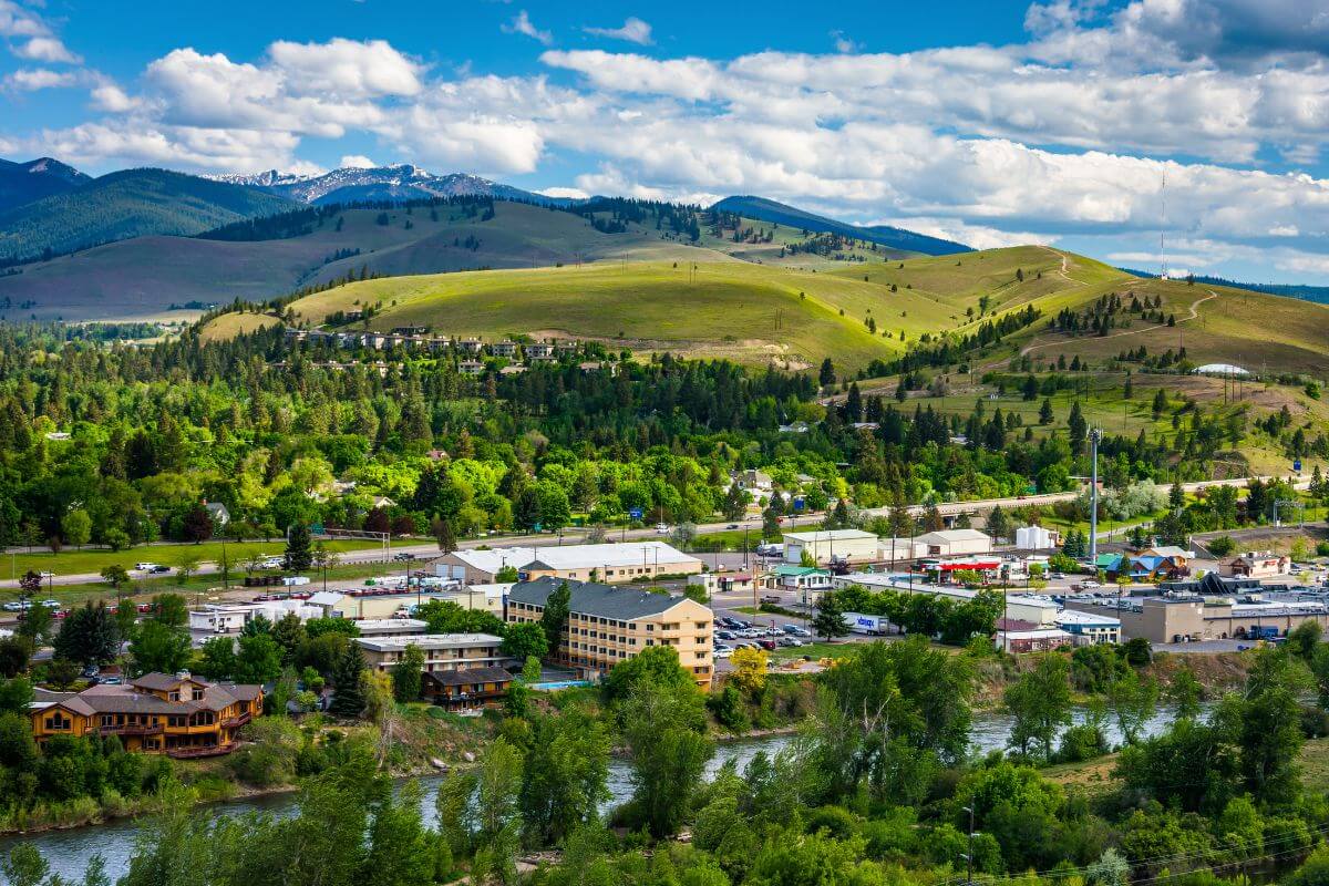 A Montana town surrounded by lush greenery with mountains in the background.