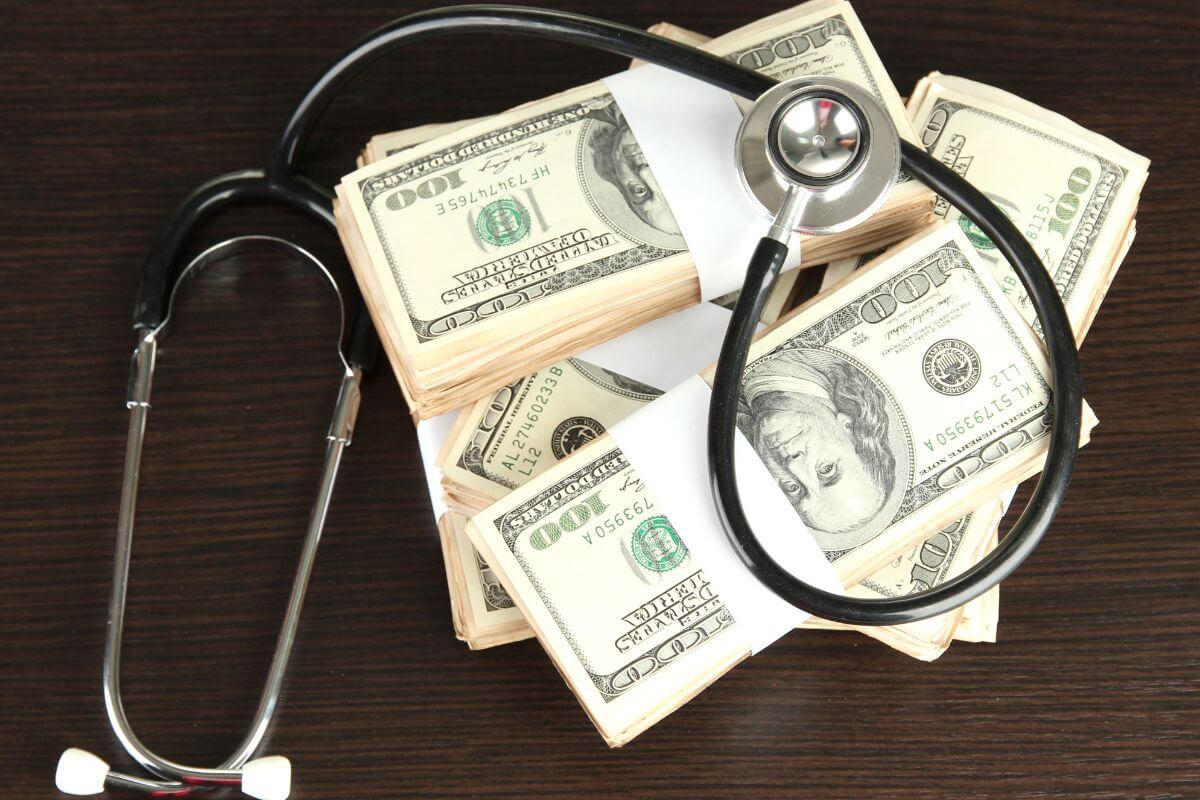 A stethoscope sits on top of a stack of money