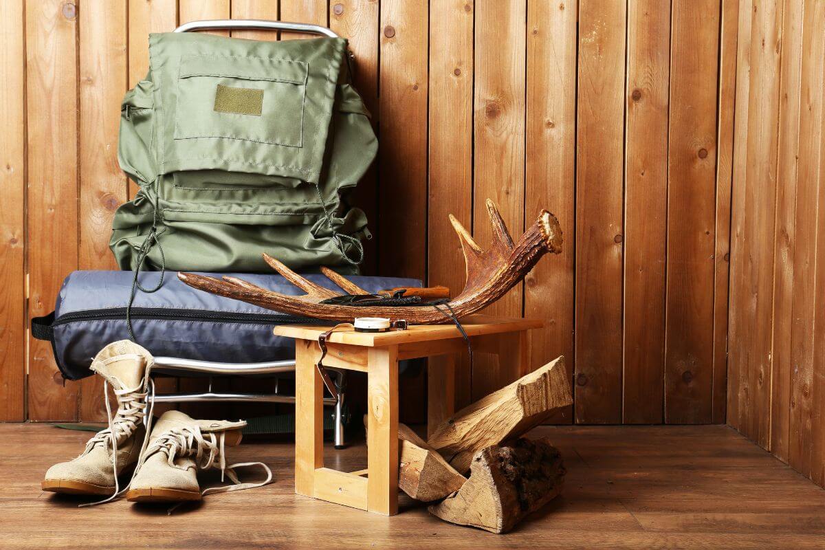 Montana hunting gear, including a backpack and hunting boots, next to an antler sitting on top of a wooden table