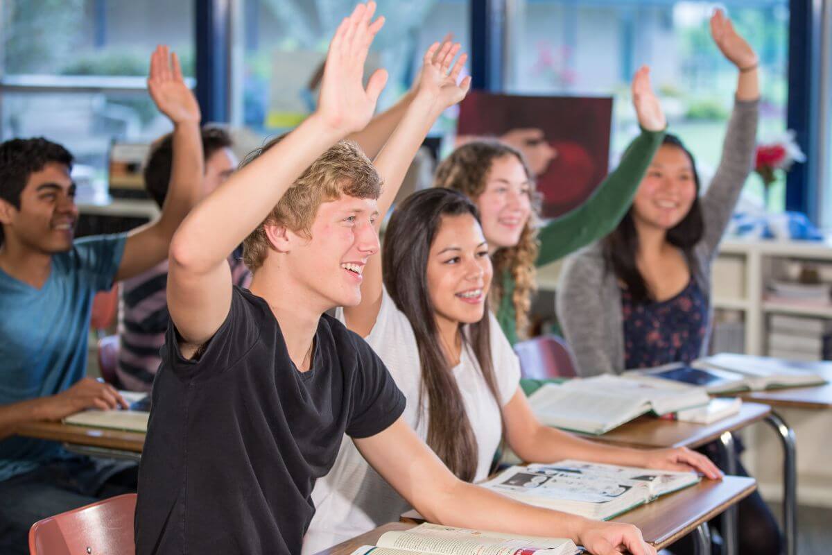 A group of students raising their hands in a classroom in Montana 