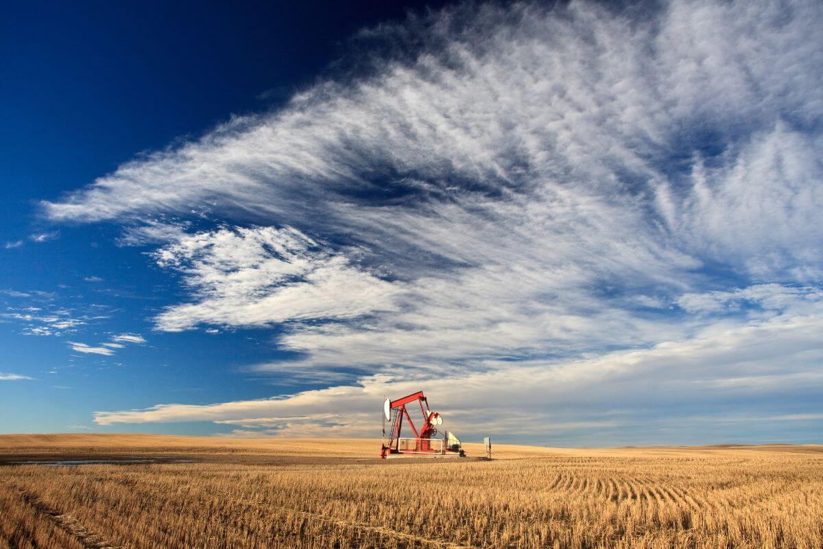 An oil pump in a field under a blue sky in Montana.