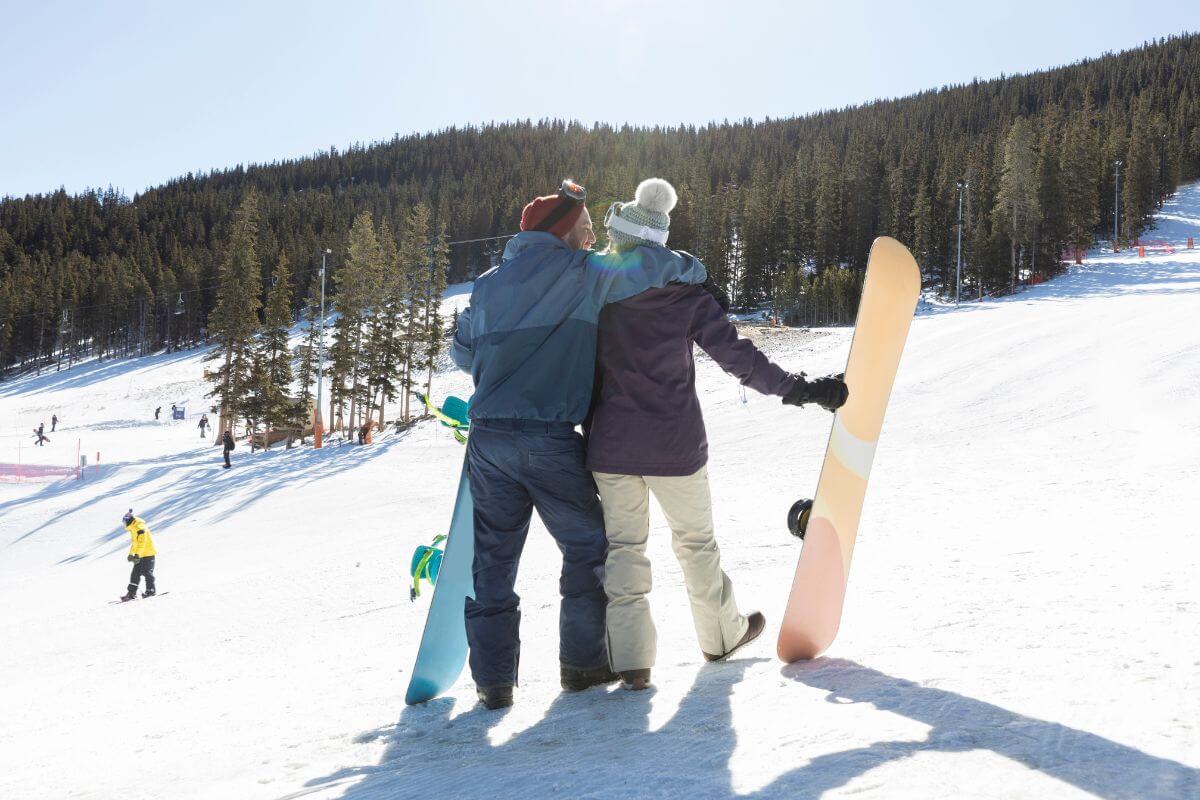 A man has his arm around a woman as they prepare to enjoy a day of snowboarding in the slopes of Montana.