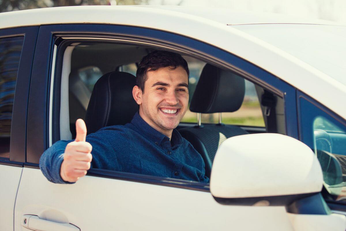 A man giving thumbs up while driving a car in Montana.