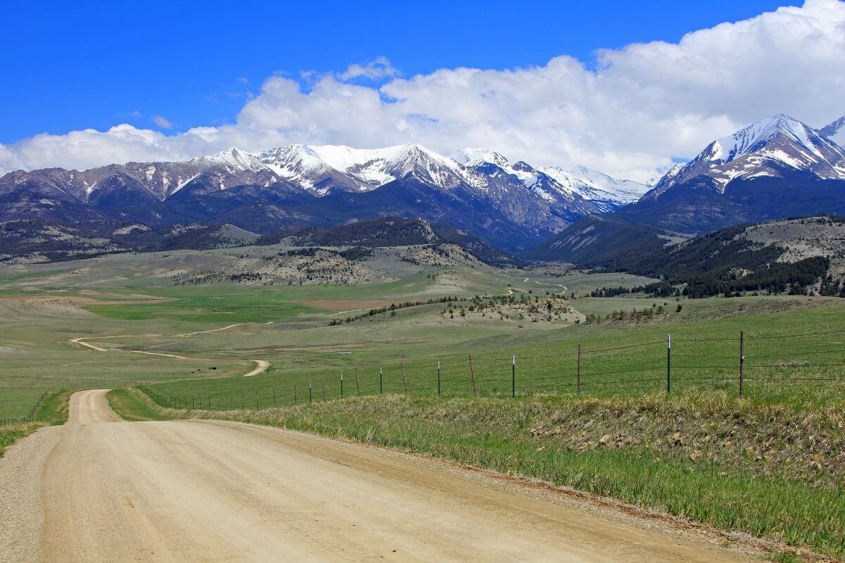 A dirt road winding through majestic mountains of Montana in Big Timber.