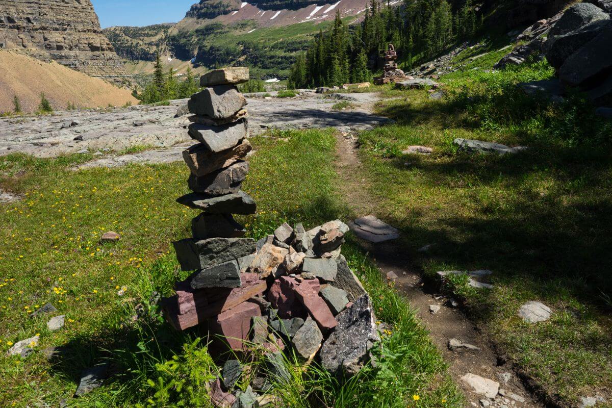 A stone cairn marks the Boulder Pass Trail in a mountainous area of Glacier National Park