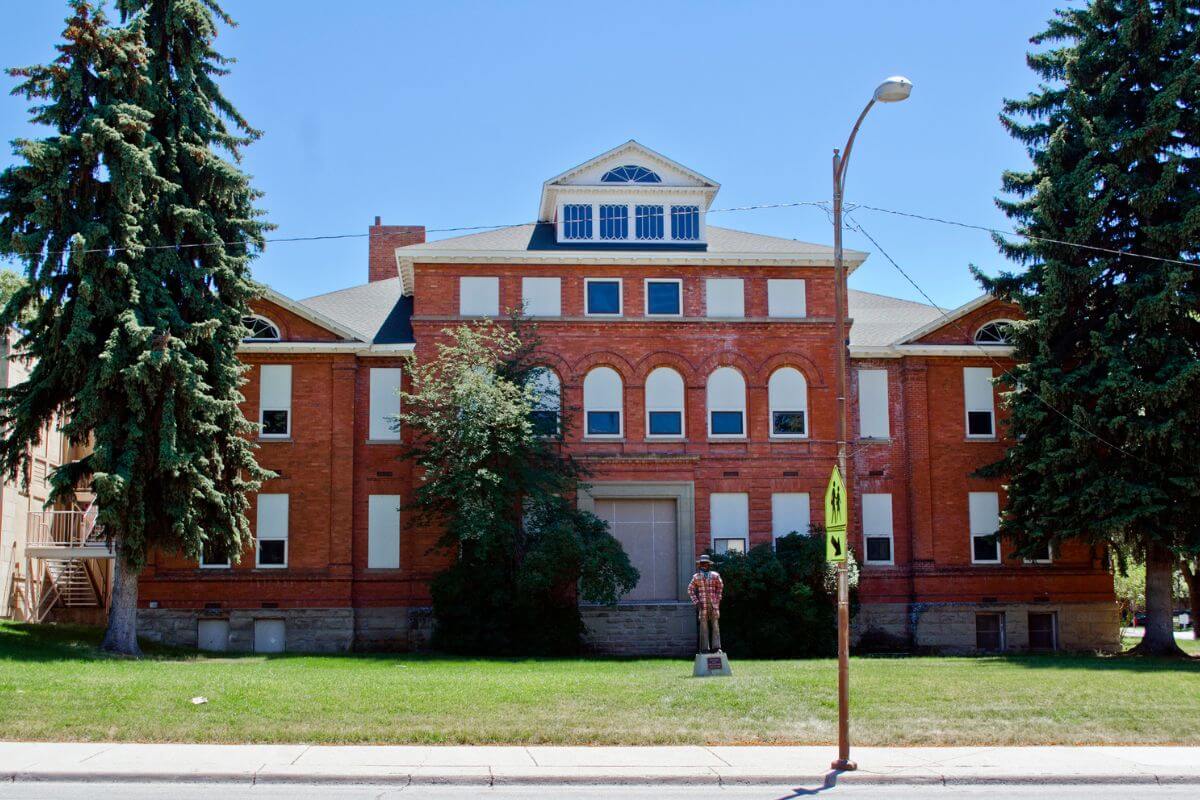 A large brick building with a statue in front of it located in Montana