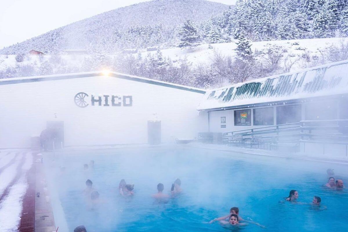 People enjoy a dip in the steaming waters of Chico Hot Springs in the cold of winter in Montana