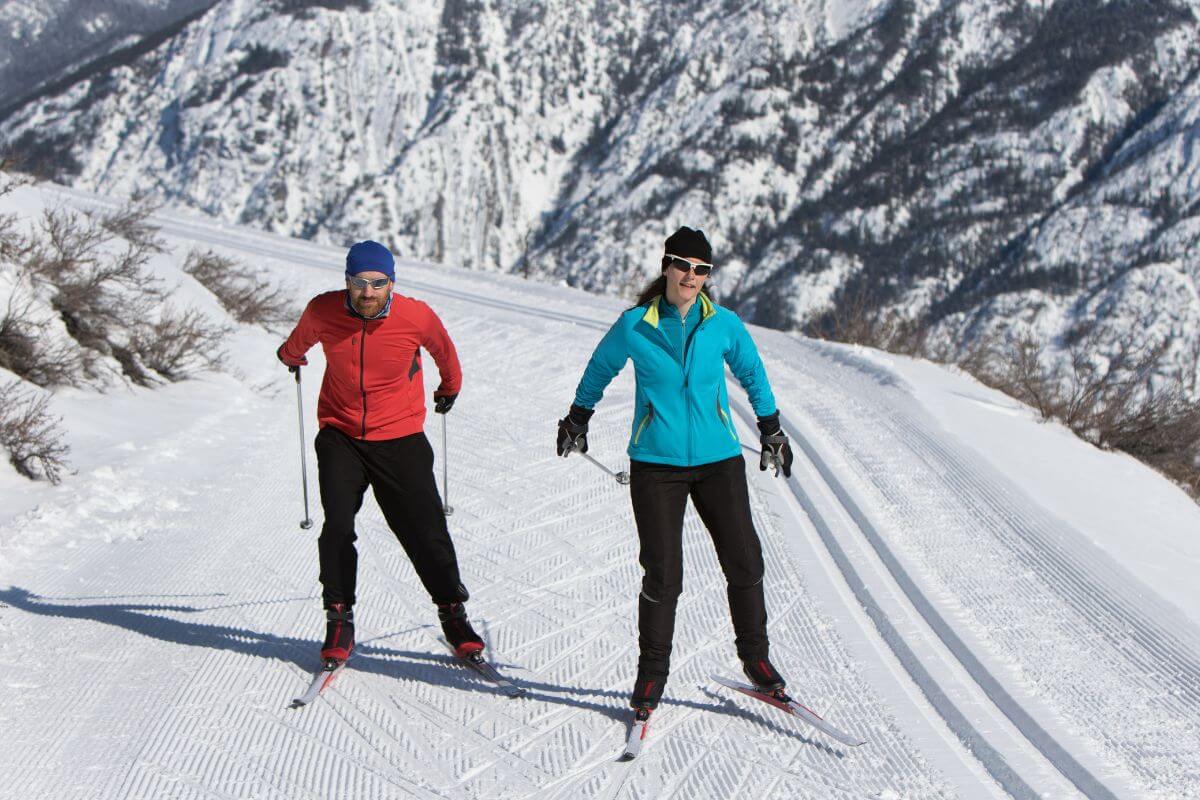 Two people cross country skiing on a snowy trail Yellowstone National Park.