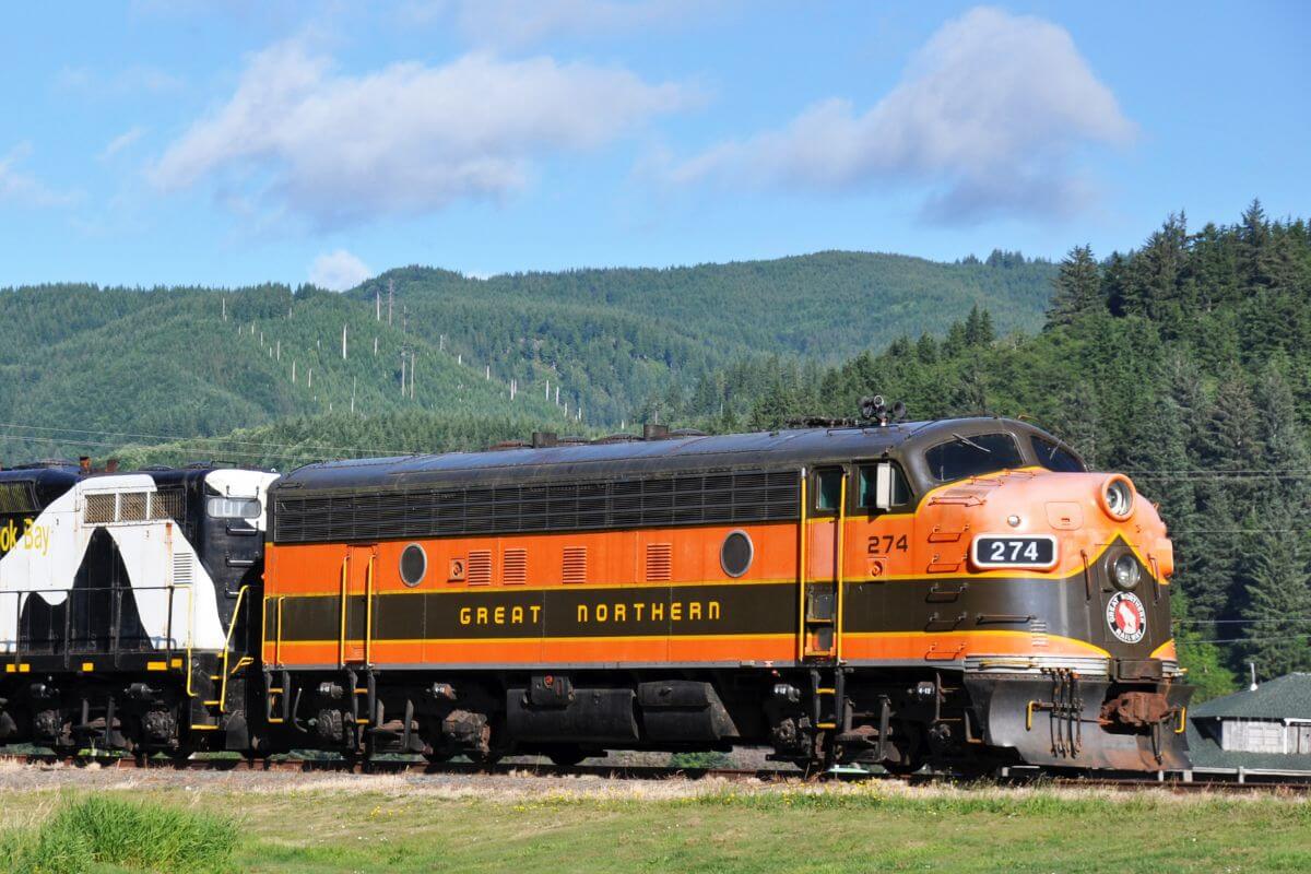An orange and black train on the railroad tracks in Montana.
