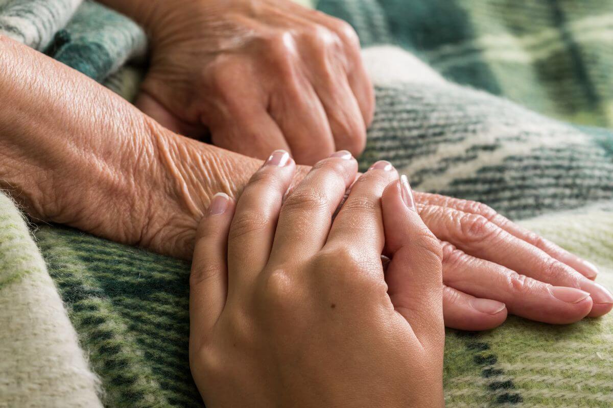 A person holding an elderly woman's hand in Montana.