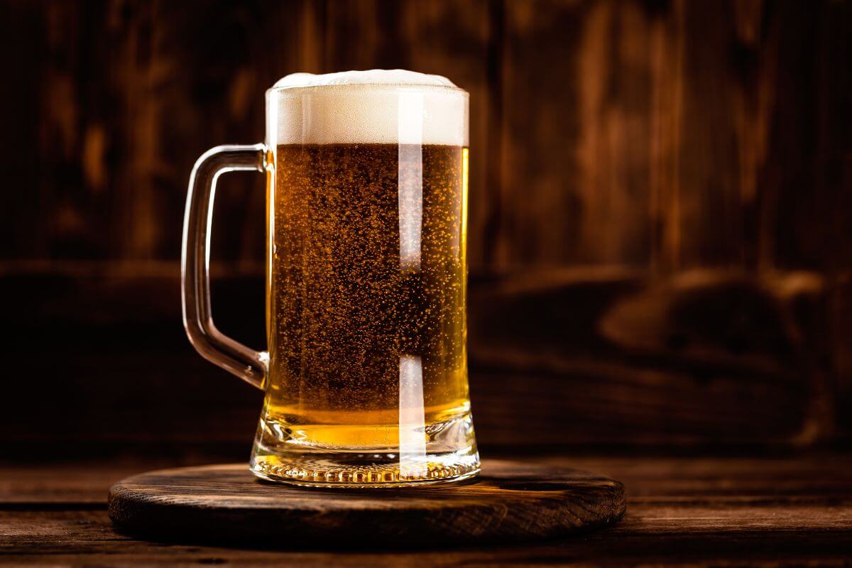 A mug of beer sitting on a wooden table