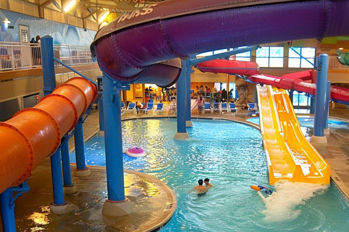 A large indoor pool with various types of water slides at The Reef Indoor Waterpark.