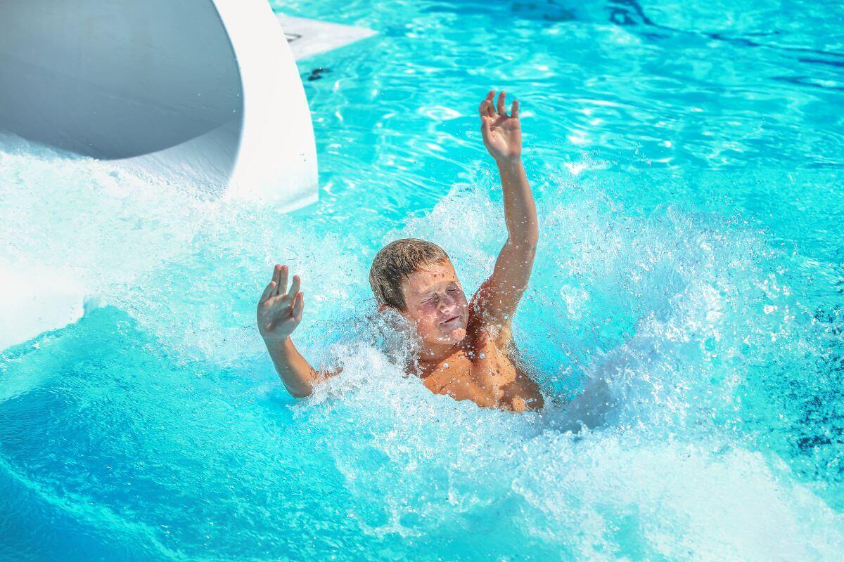A boy enters the pool through a water slide during their Montana family vacation.