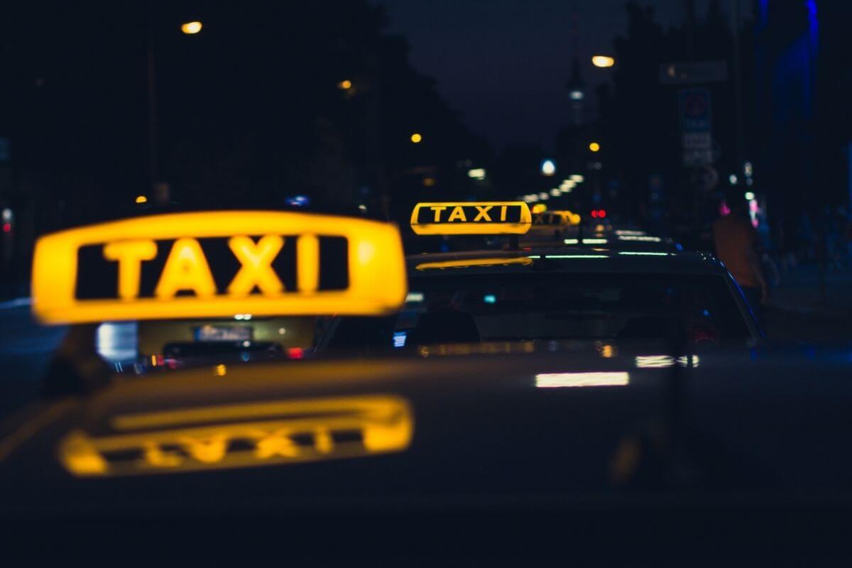 A group of taxi cabs on a street at night providing Montana transportation services.