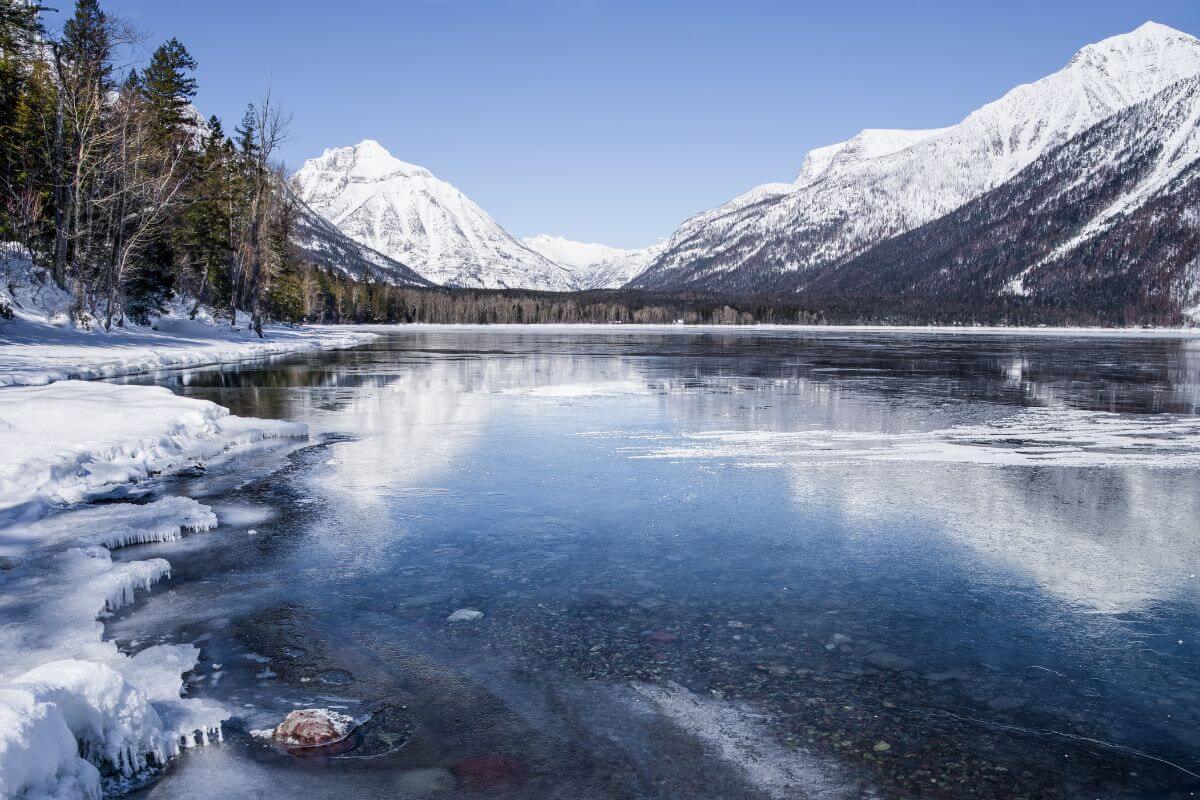 A frozen lake in Montana with mountains in the background.