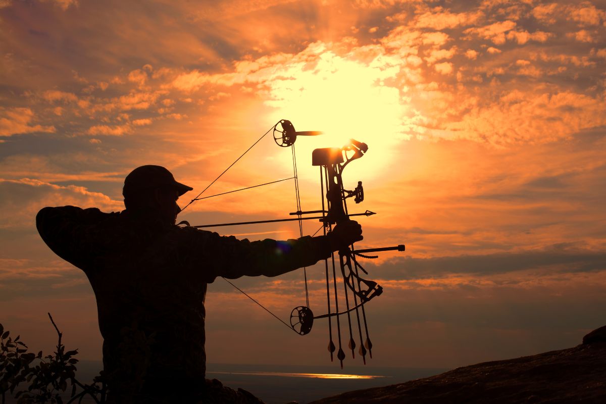 A hunter tests out his bow and arrow for antelope hunting in Montana during the golden hour.