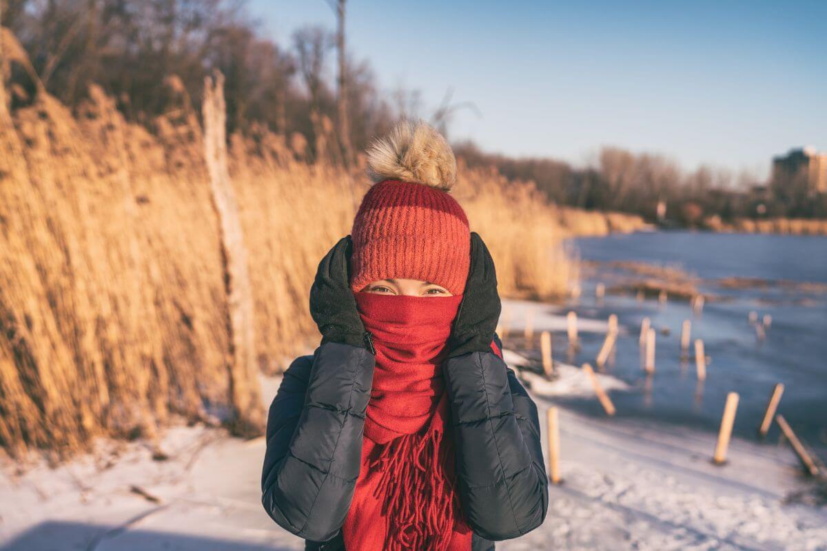 A woman with a scarf covering her face near a lake in Montana.