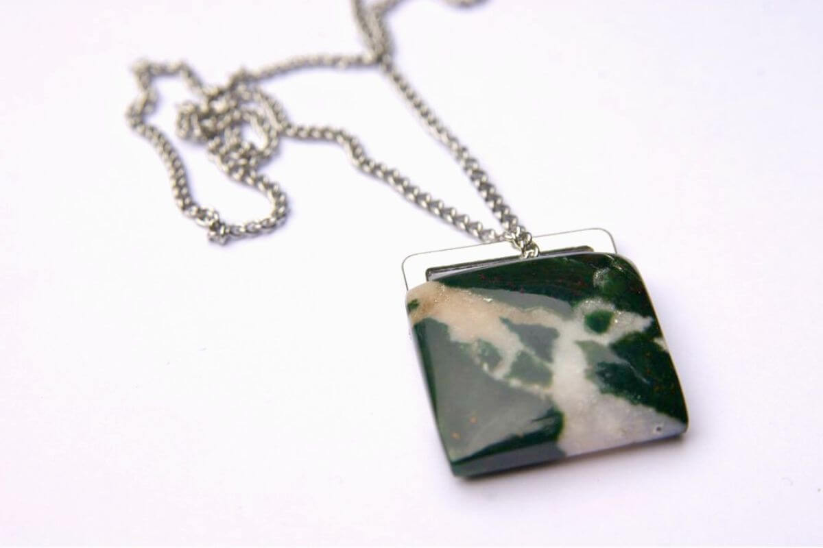 A green and white Montana Agate pendant on a silver chain.