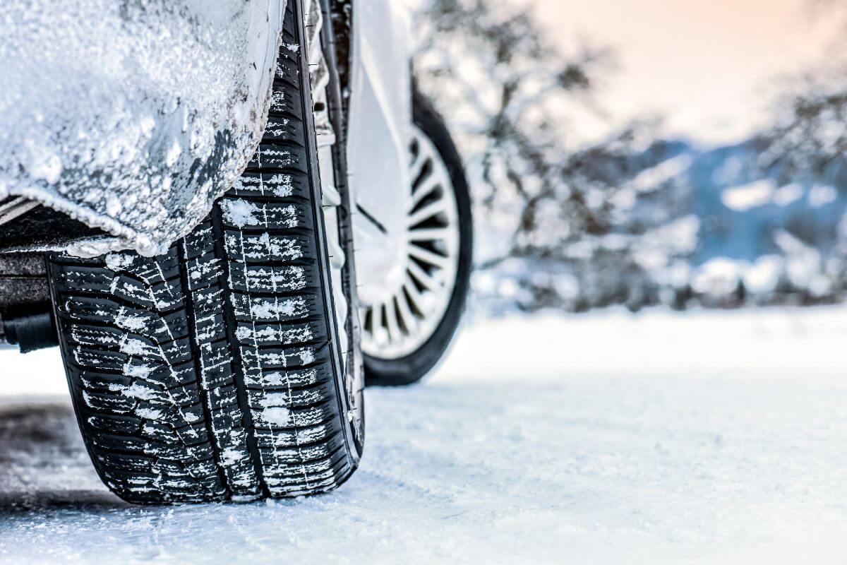 A close up of a car tire in the snowy terrain of Montana.