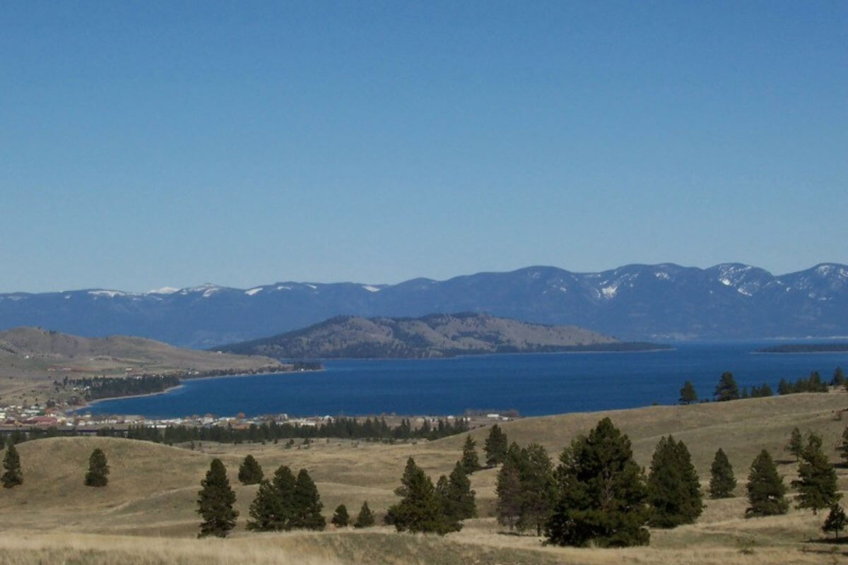A panoramic view of a lake surrounded by mountains in Wild Horse Island, one of the best areas to watch Montana horses.