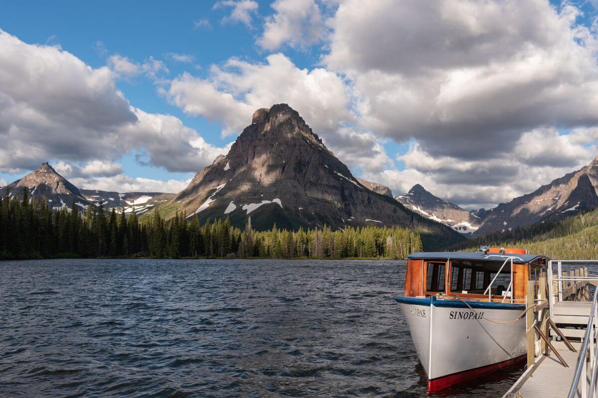 A boat available for charter is secured to a dock on a mountain lake in Montana.




