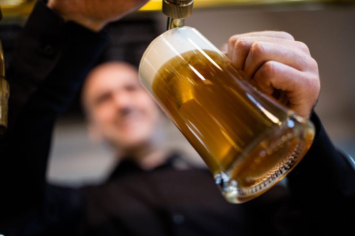 A man pouring a beer into a glass in Montana.