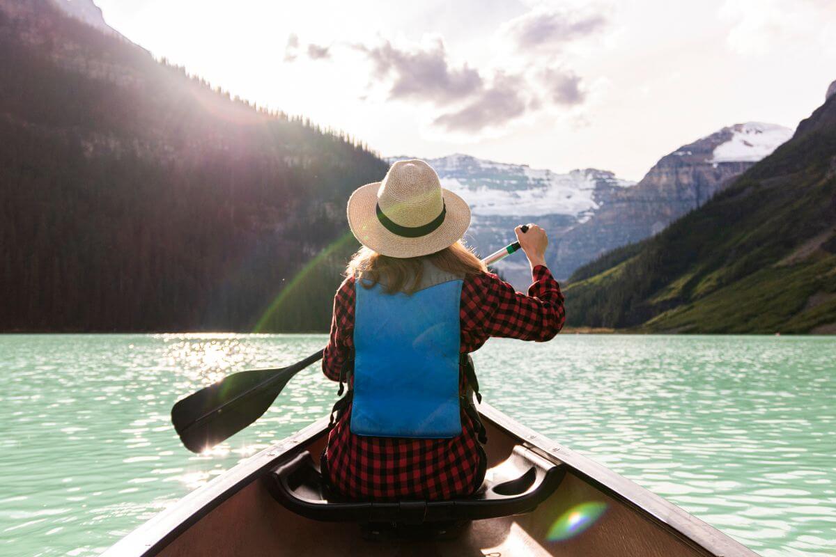 A woman paddles a canoe on a Montana lake.