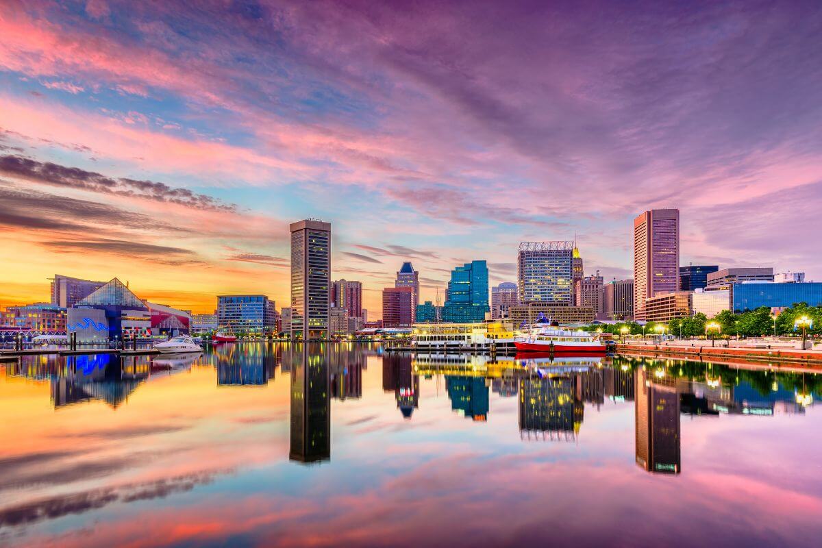 The skyline of Baltimore, Maryland is reflected in the water.